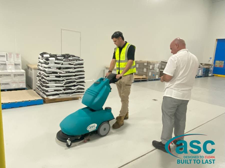 men with walk behind sweeper